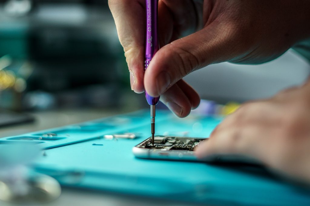 Closeup shot of a person repair a mobile in mobile repair smartphone workshop