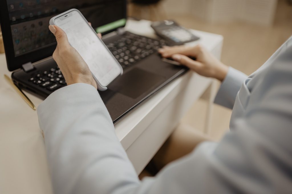 businesswoman using mobile and laptop / IT